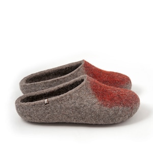 May include: A pair of gray wool slippers with a red accent on the toe. The slippers are made of felted wool and have a simple, comfortable design.
