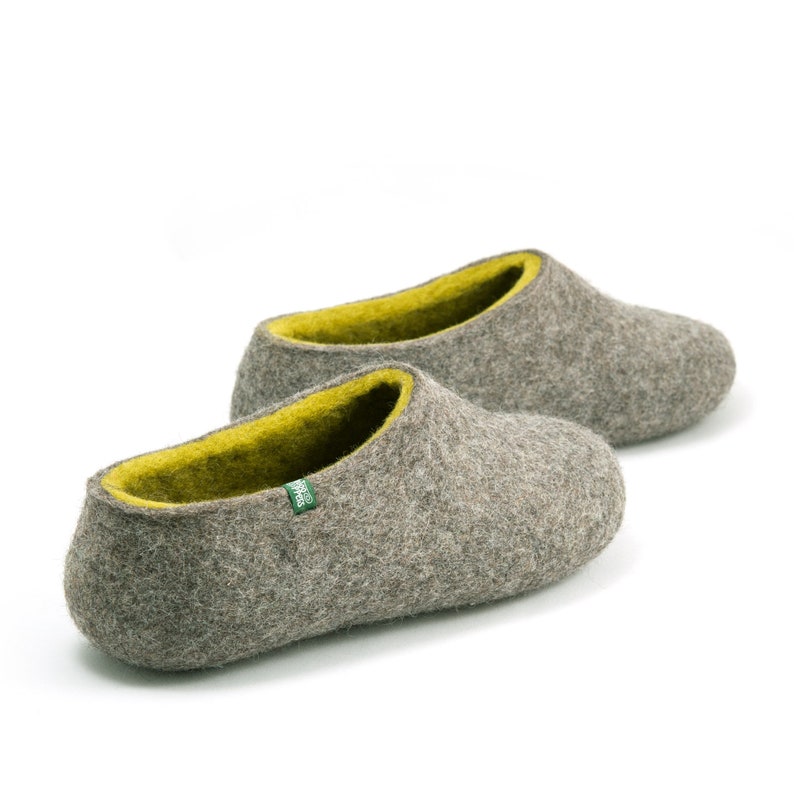 May include: A pair of gray felt slippers with a bright yellow lining. The slippers have a rounded toe and a simple design.