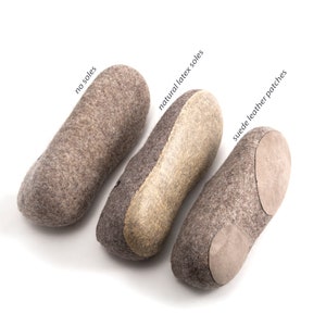 May include: Three pairs of felt slippers with different soles: no soles, natural latex soles, and suede leather patches. The slippers are all gray and have a rounded shape.