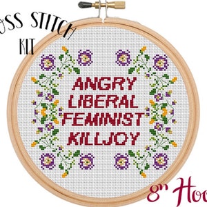 May include: Cross stitch kit featuring a white embroidery hoop with a red and white design that says "Angry Liberal Feminist Killjoy" surrounded by a floral border with purple and yellow flowers. The hoop is 8 inches in diameter.