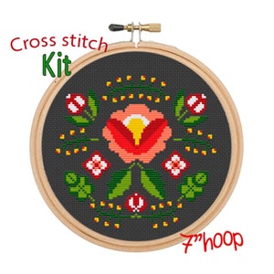 May include: Cross stitch kit featuring a floral design with a red, orange, and yellow flower surrounded by green leaves and yellow dots on a dark gray background. The kit includes a 7-inch hoop.