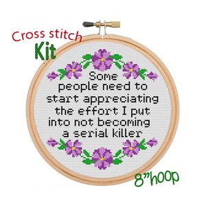 May include: Cross stitch kit with a white fabric background and purple flowers around the border. The text reads "Some people need to start appreciating the effort I put into not becoming a serial killer". The kit is for an 8 inch hoop.