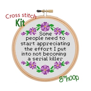 May include: Cross stitch kit with a white fabric background and purple flowers around the border. The text reads "Some people need to start appreciating the effort I put into not becoming a serial killer". The kit is for an 8 inch hoop.