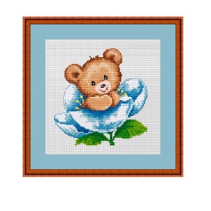 May include: A brown teddy bear with a blue flower behind it. The bear is sitting in the flower and has its paws crossed in front of it. The flower has green leaves and a stem.