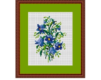 May include: A framed cross-stitch embroidery featuring a bouquet of blue bell flowers with green leaves on a white background. The frame is brown with a green mat.
