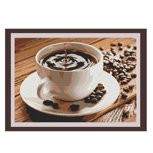 May include: A white ceramic coffee cup filled with dark brown coffee. The coffee has a swirl pattern on the surface. The cup is sitting on a white saucer with coffee beans scattered around it. The saucer is on a wooden surface.