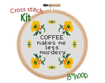 May include: Cross stitch kit featuring a white embroidery hoop with a design of yellow flowers and the text "COFFEE makes me less murdery". The hoop is 8 inches in diameter.