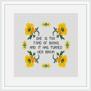 Op de afbeelding: Borduurwerk met kruissteek met gele bloemen en groene bladeren rond de tekst "Ze is te dol op boeken en het heeft haar brein veranderd."