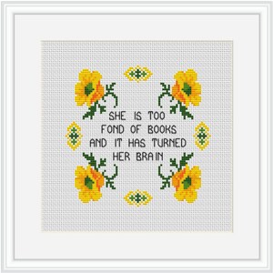 Op de afbeelding: Borduurwerk met kruissteek met gele bloemen en groene bladeren rond de tekst "Ze is te dol op boeken en het heeft haar brein veranderd."
