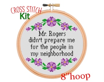 May include: Cross stitch kit featuring the quote "Mr. Rogers didn't prepare me for the people in my neighborhood." The design is surrounded by purple flowers and is meant to fit an 8 inch hoop.