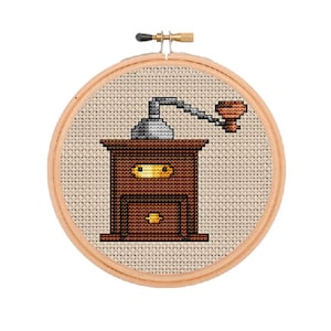 May include: A brown wooden coffee grinder with a silver crank and a brown handle. The grinder is on a white background.