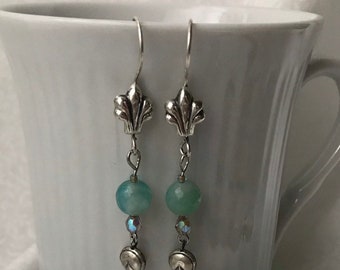 Agate 8 mm faceted aqua color bead, 4x3mm oval crystal bead, seed bead accents.  Sterling ear wire and leaf design dangle (#113).