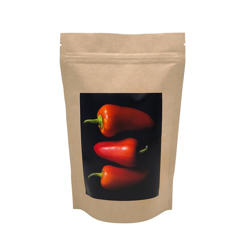 May include: A brown paper bag with a clear window showing three red peppers on a black background.