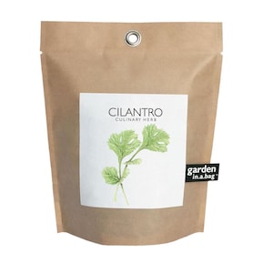 May include: A brown paper bag with a white label that says "Cilantro Culinary Herb" and a drawing of cilantro. The bag has a silver grommet and a black label that says "garden in.a.bag"