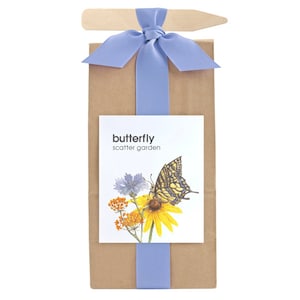 May include: A brown paper bag with a blue ribbon tied around it. The bag has a white label that says "butterfly scatter garden" and features a butterfly and flowers.