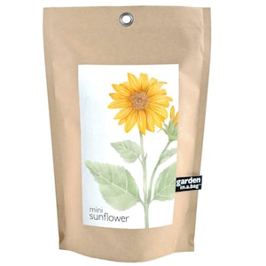 May include: A brown paper bag with a white label featuring a watercolor illustration of a yellow sunflower. The label reads "mini sunflower" and "garden in a bag".