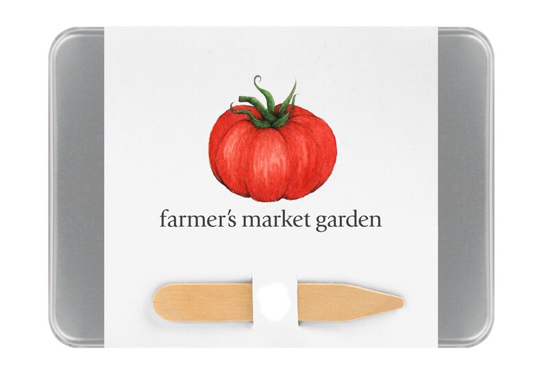May include: A silver tin with a white label featuring a hand-drawn illustration of a red tomato. The label also includes the text "farmer's market garden". A wooden stick is included in the tin.