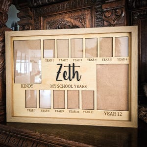 May include: A light wooden photo frame designed for school years, from Kindy to Year 12. The name "Zeth" is displayed in a cursive font. The text "MY SCHOOL YEARS" is also visible.