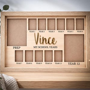 May include: A rectangular light wood school years photo frame featuring the name Vince in gold script and the text MY SCHOOL YEARS. It includes one large vertical slot for Prep, six small slots for Years 1-6, five small slots for Years 7-11, and one large vertical slot for Year 12.