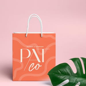 May include: A coral orange shopping bag with white handles and a white logo that says "Patrick & Company" and "Pat co" in a stylized font. The bag has a wavy, abstract pattern.