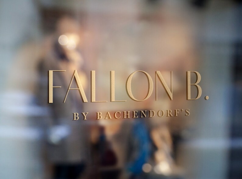 May include: Gold lettering on a glass storefront reads "FALLON B. BY BACHENDORF'S".