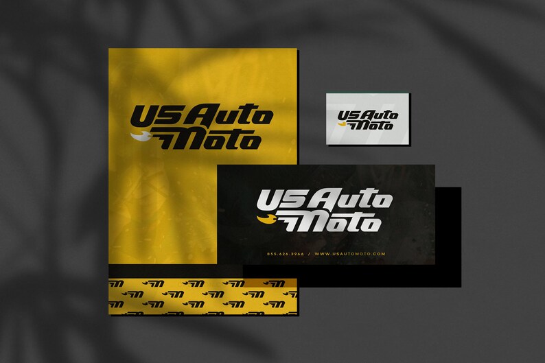 May include: A black and yellow business card with the text "US Auto Moto" in white lettering. The card has a black background with a yellow logo and the website address "www.usautomoto.com".