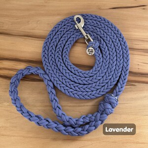 May include: A lavender braided dog leash with a silver clip and a small metal tag that says "Braids 4 U".