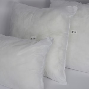 May include: Three white pillow inserts in various sizes. The labels indicate sizes of 30.5cm x 45.7cm, 40.6cm x 40.6cm, and 45.7cm x 45.7cm. The pillows are soft and fluffy, suitable for bedding or decorative use.