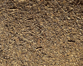 May include: Close-up of a pile of dried, brown, and green herbs. The herbs are finely chopped and look like they could be used for cooking or making tea.