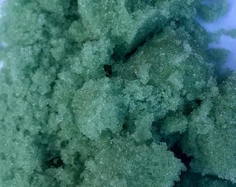 May include: Close-up of a pile of green sugar crystals.