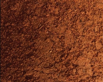 May include: Close-up of a brown suede fabric with a textured surface.