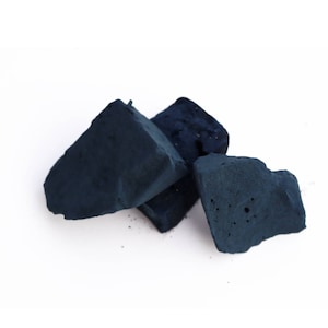 Può includere: Tre blocchi di tintura indigo blu scuro, un colorante naturale utilizzato per tingere i tessuti.