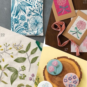 Pode incluir: Uma variedade de itens bordados com desenhos florais. Inclui uma bolsa branca com bordado azul-petróleo, cartões com bordado floral rosa e azul-petróleo e broches redondos com bordado floral.