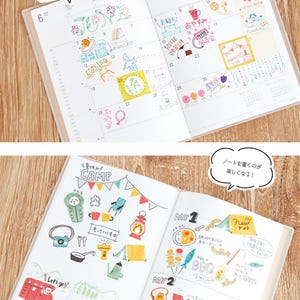 May include: Open notebook with colorful hand-drawn illustrations. The pages feature doodles of flowers, food, and camping scenes. Text in Japanese is visible, along with the phrase "Let's go!"