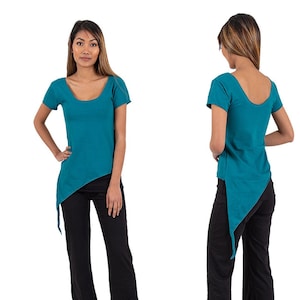 Może przedstawiać: Turkusowa asymetryczna bluzka z krótkimi rękawami i okrągłym dekoltem. Bluzka jest połączona z czarnymi spodniami.