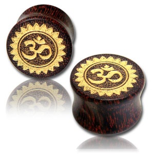 May include: Pair of wooden ear gauges with a dark brown finish and a gold Om symbol in a sunburst design.