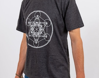 Puede incluir: Una camiseta gris oscuro con un diseño geométrico blanco en la parte delantera. El diseño es un patrón complejo de círculos y líneas.