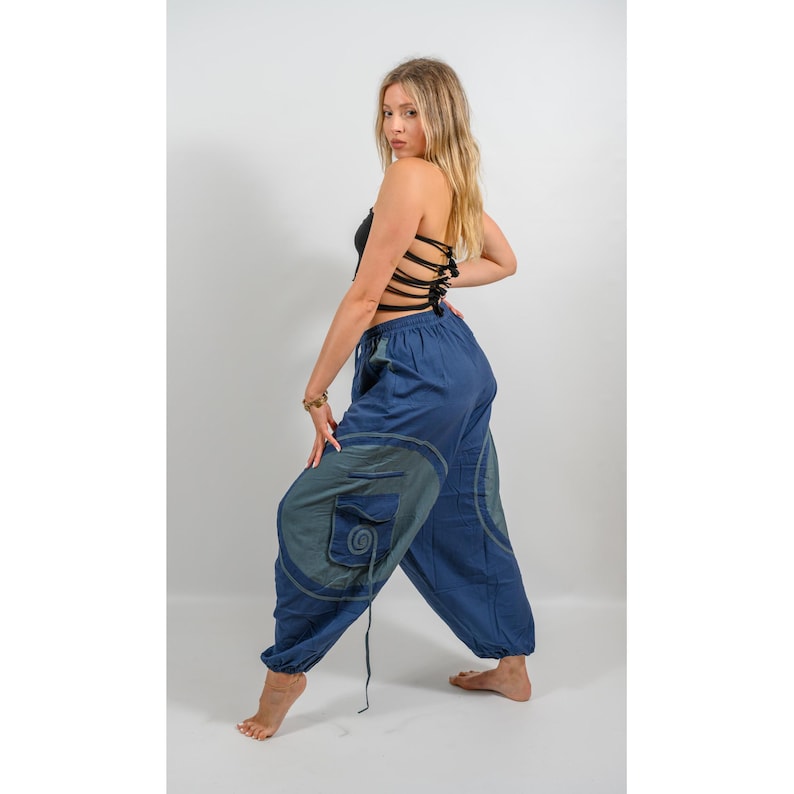 Puede incluir: Un pantal&oacute;n de algod&oacute;n azul con un dise&ntilde;o de espiral y un bolsillo en la pierna izquierda. El pantal&oacute;n es holgado y tiene un cord&oacute;n en la cintura.