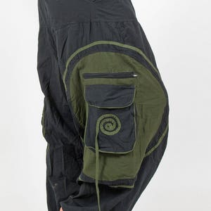 May include: Black and green cargo pants with a large pocket on the right leg. The pants have a drawstring waist and a relaxed fit.