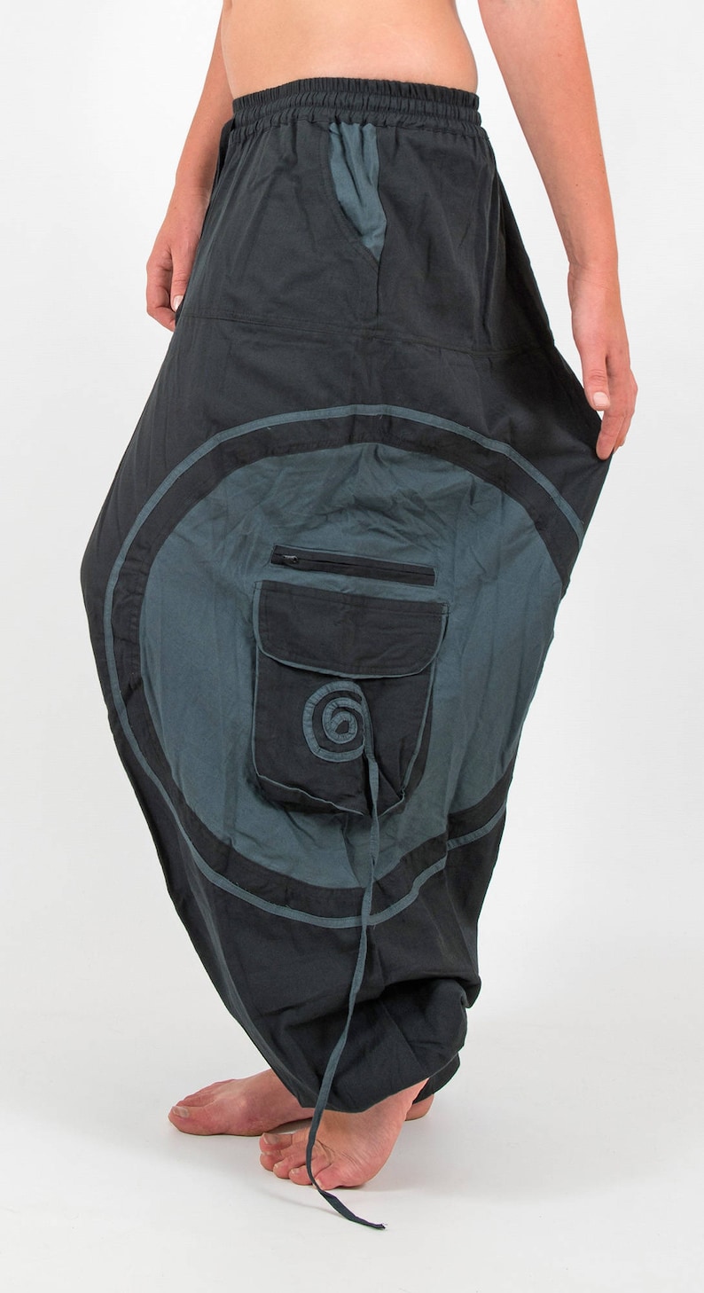 Puede incluir: Pantal&oacute;n de algod&oacute;n negro y gris con un gran dise&ntilde;o circular y un bolsillo negro con un peque&ntilde;o dise&ntilde;o circular. El pantal&oacute;n tiene una cintura con cord&oacute;n.