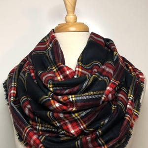 May include: A black, red, white, and yellow plaid infinity scarf with frayed edges.