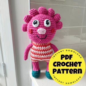 May include: A pink crochet doll with a smiling face, white eyes, and a striped red and white top. The doll has a round head with spiky details and teal shoes. A yellow circle with the text "PDF CROCHET PATTERN" is in the image.