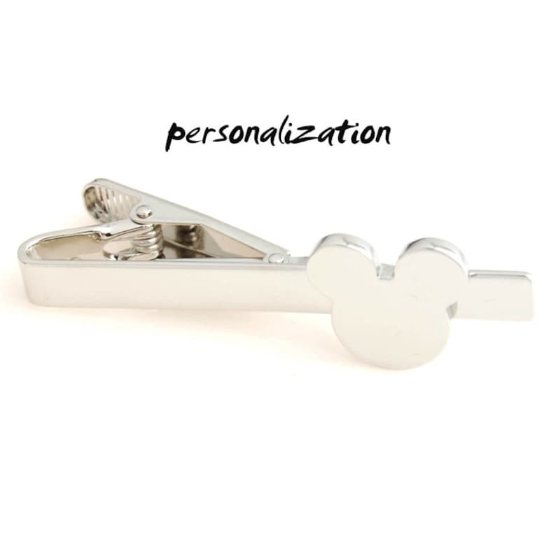 May include: Silver tie clip with a Mickey Mouse head design.