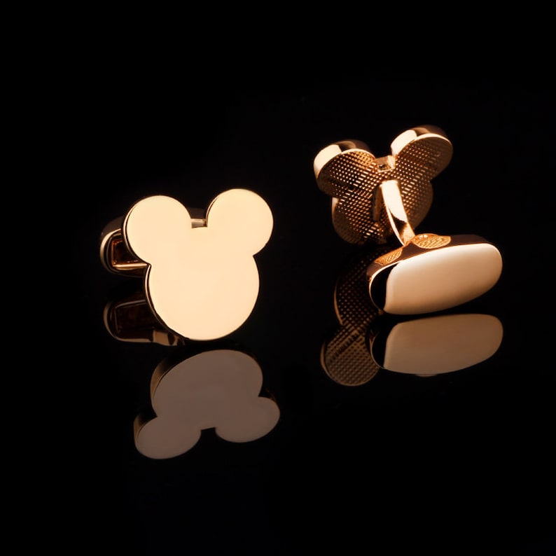 May include: A pair of gold-tone cufflinks featuring a Mickey Mouse head design.