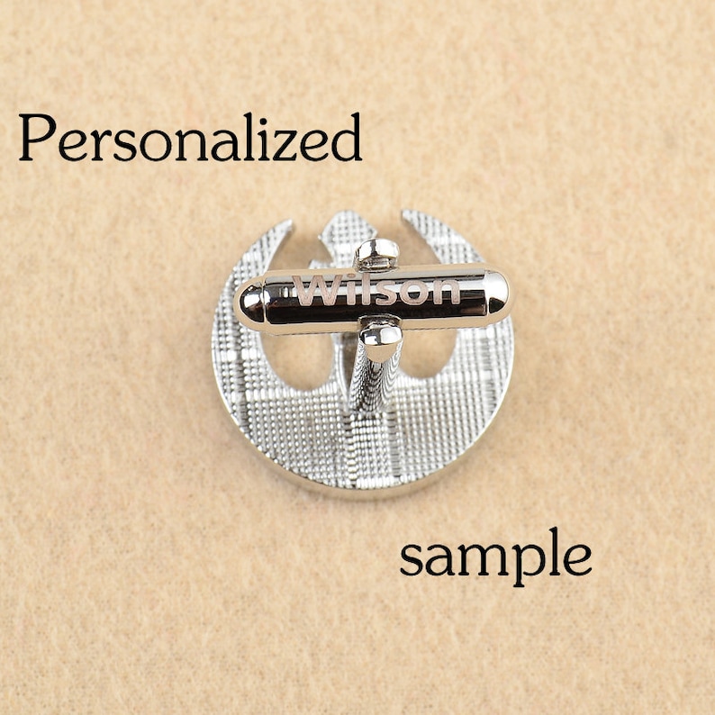 May include: Silver cufflinks with a Rebel Alliance symbol design. The cufflinks are engraved with the name "Wilson".