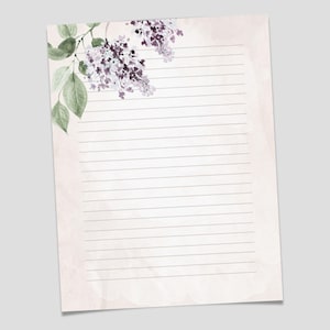 Puede incluir: Papelería imprimible con un diseño floral. El papel tamaño carta presenta un fondo estilo acuarela con un arreglo floral de lilas en la esquina superior izquierda. El papel está rayado y mide 21,6 cm x 27,9 cm.