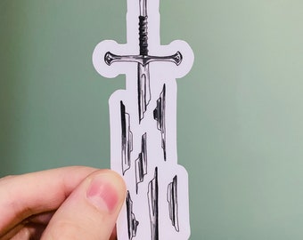 May include: A black and white illustration of a sword breaking into pieces. The sword is depicted as a traditional, straight-bladed sword with a crossguard and a pointed tip. The pieces of the sword are scattered around the blade, suggesting that it has been shattered.
