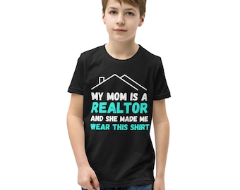 May include: Black t-shirt with white text that reads "My Mom is a Realtor and she made me wear this shirt". The text is surrounded by a white house outline. A young person is wearing the shirt.