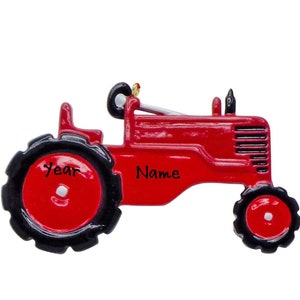 May include: Red tractor Christmas ornament with black wheels and a black grill. The ornament has the words "Year" and "Name" on it.