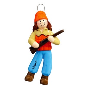 May include: A personalized Christmas ornament featuring a cartoon hunter wearing an orange hat, a yellow shirt, an orange vest, blue pants, and holding a brown shotgun. The ornament has the word "Name" written on the leg.